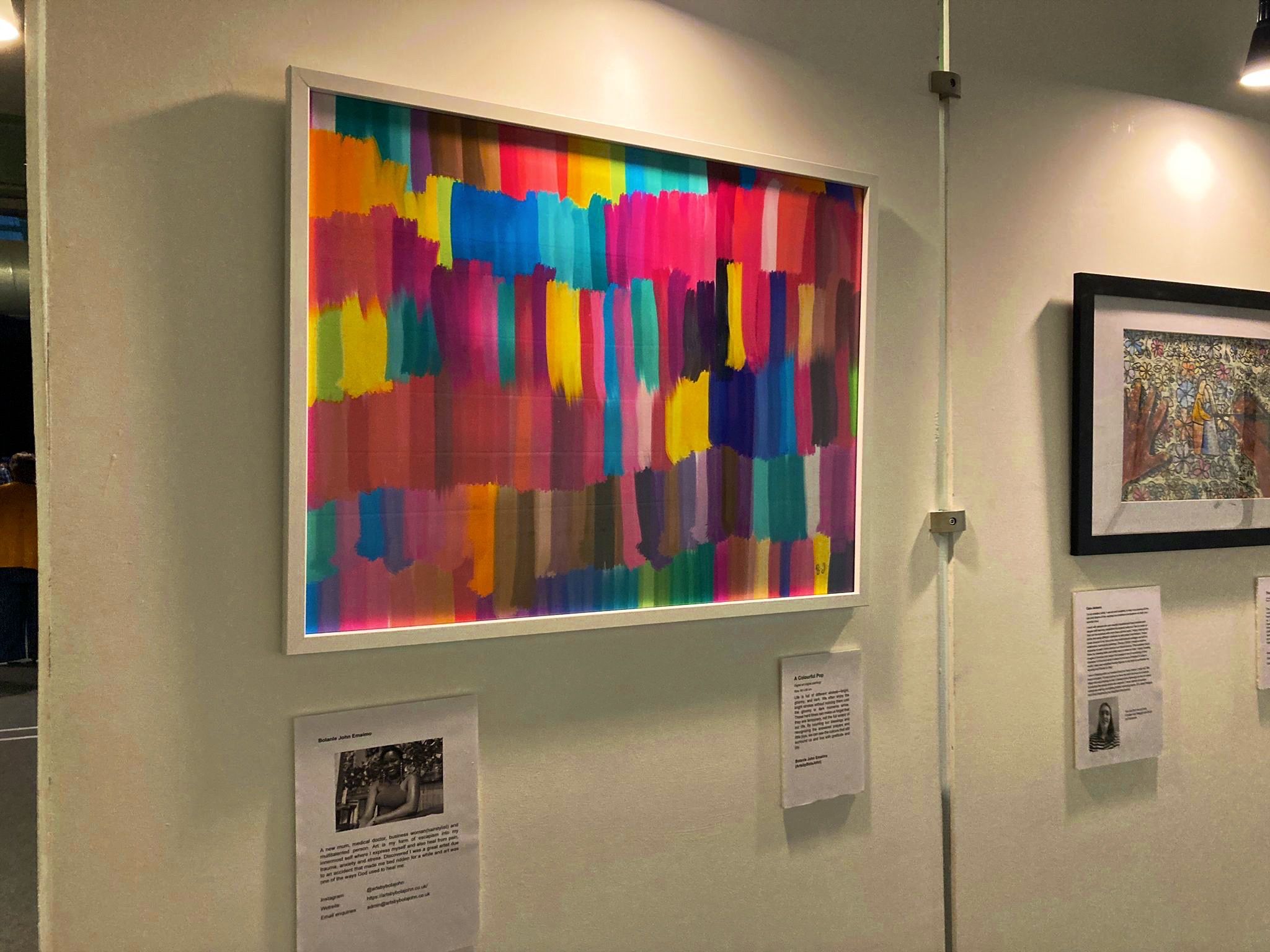 A Colourful Pop displayed beside another framed artwork